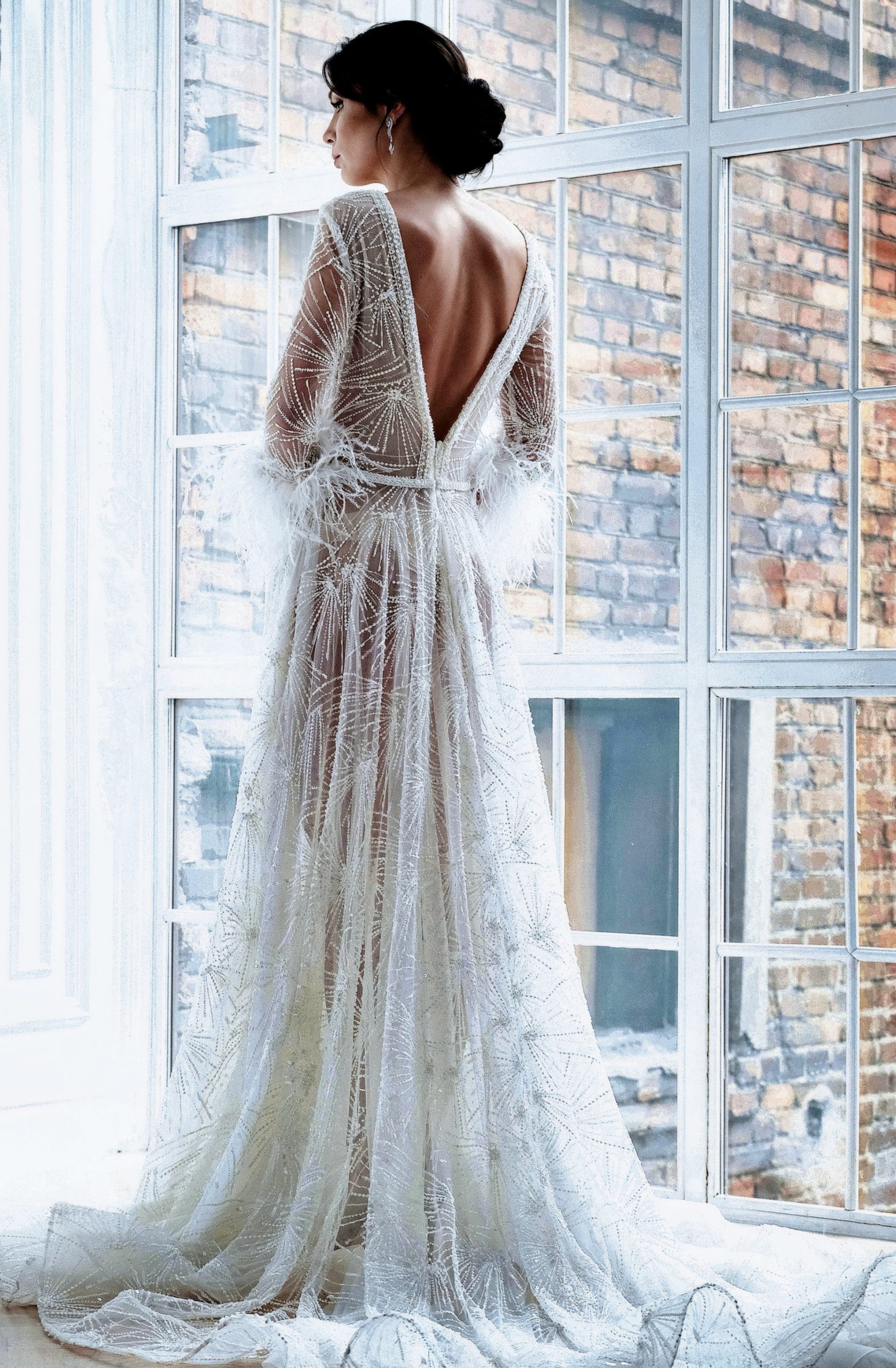 Newlywed bride standing by a large window, wearing a perfectly altered wedding dress by Rose N Silk