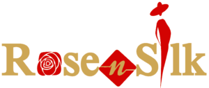 The RoseNSilk logo is designed with a solid font that displays the brand name "RoseNSilk", with the letter "o" replaced by a rose flower. A sewing line is attached to the letter "n". A silhouette of a woman standing in place of the letter "i" is featured in the logo. The woman is wearing a fashionable hat and appears to have her hand on her waist. The logo is predominantly gold and red, with hints of white in the rose flower.